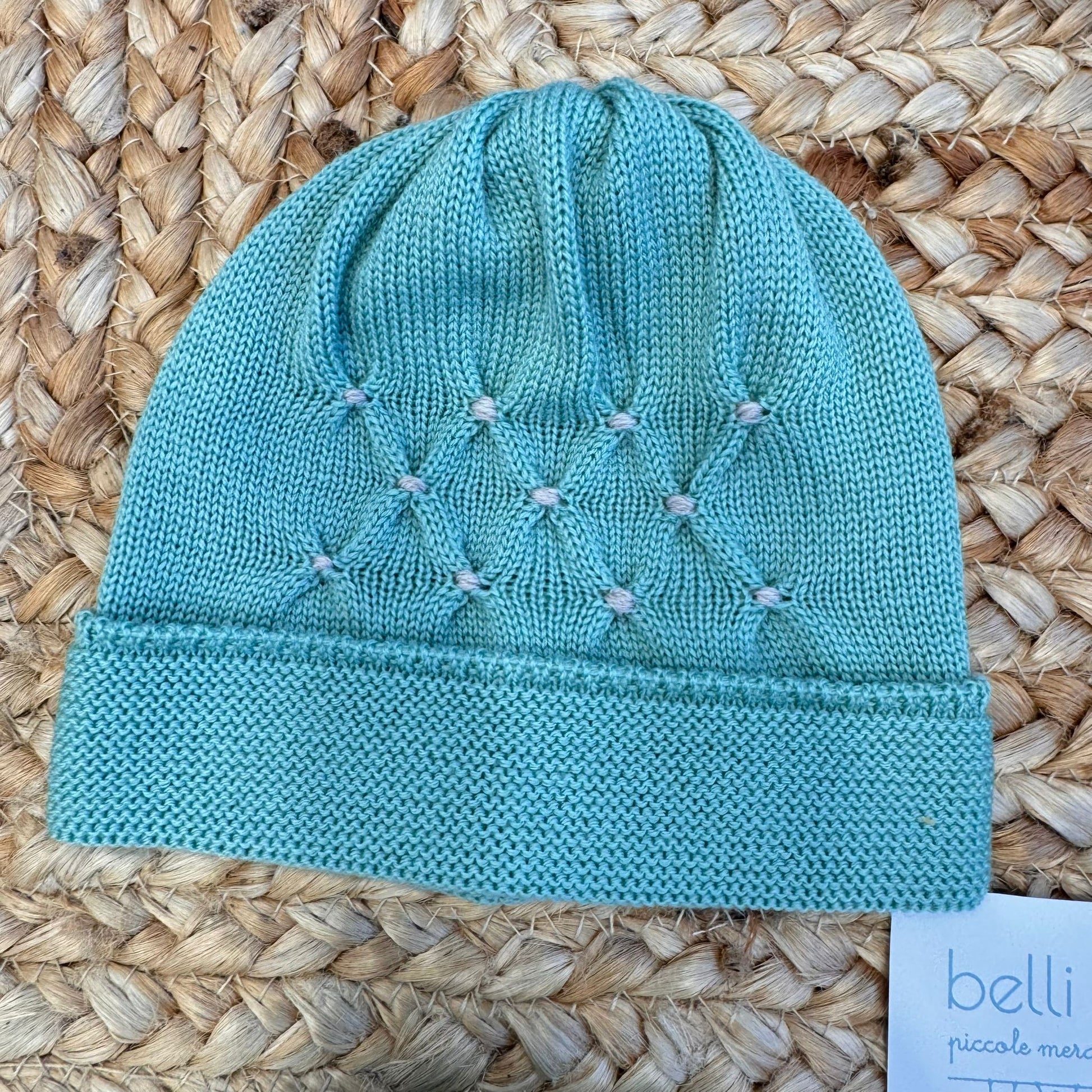 Dettaglio ricamo su cappellino verde foglia in pura lana per neonato

