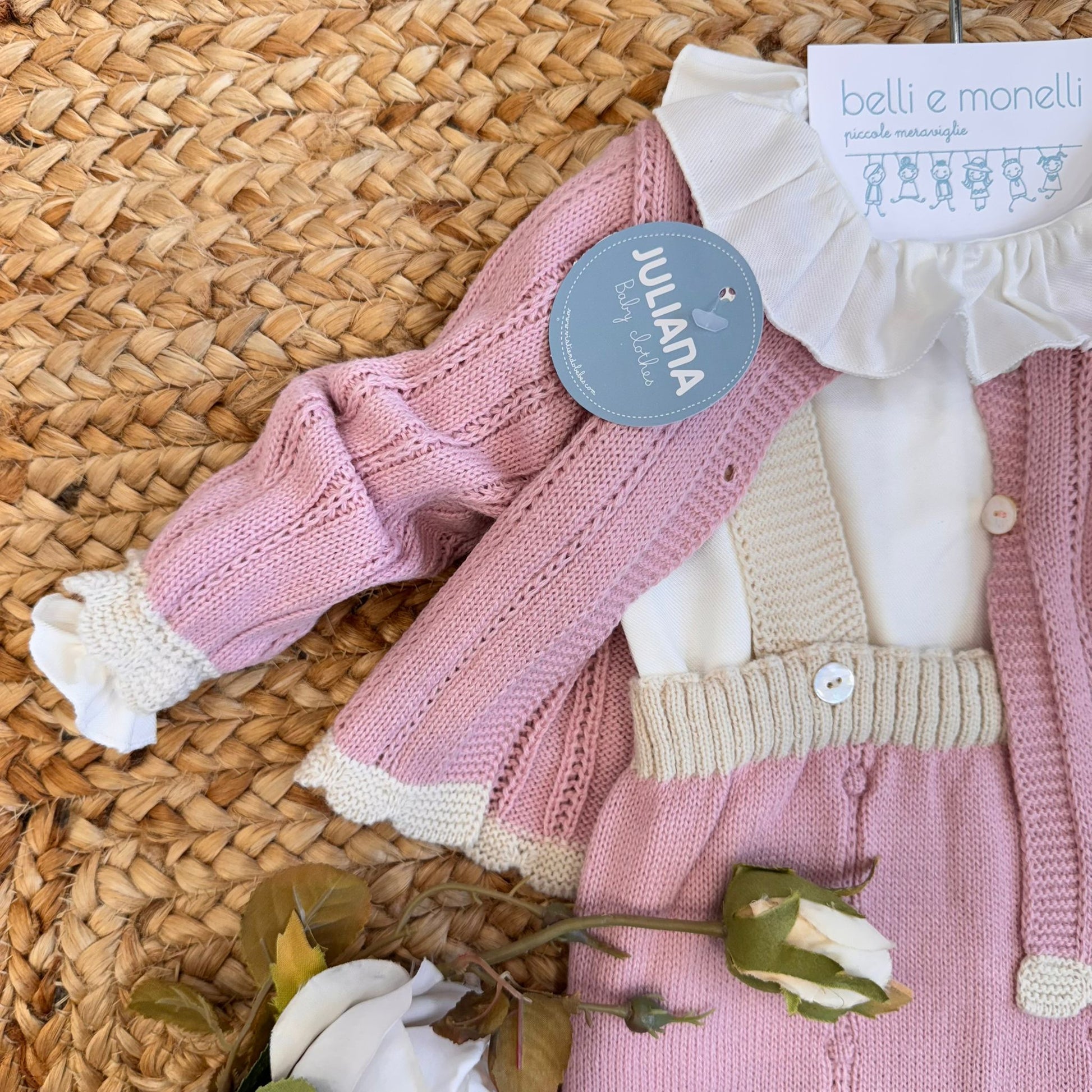 Dettaglio cardigan rosa in maglia per corredino neonata

