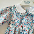 Abitino bimba floreale 100% cotone con colletto bianco e pon pon azzurri.