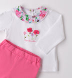 Dettaglio del colletto floreale e ricamo sulla maglia del completino neonata
