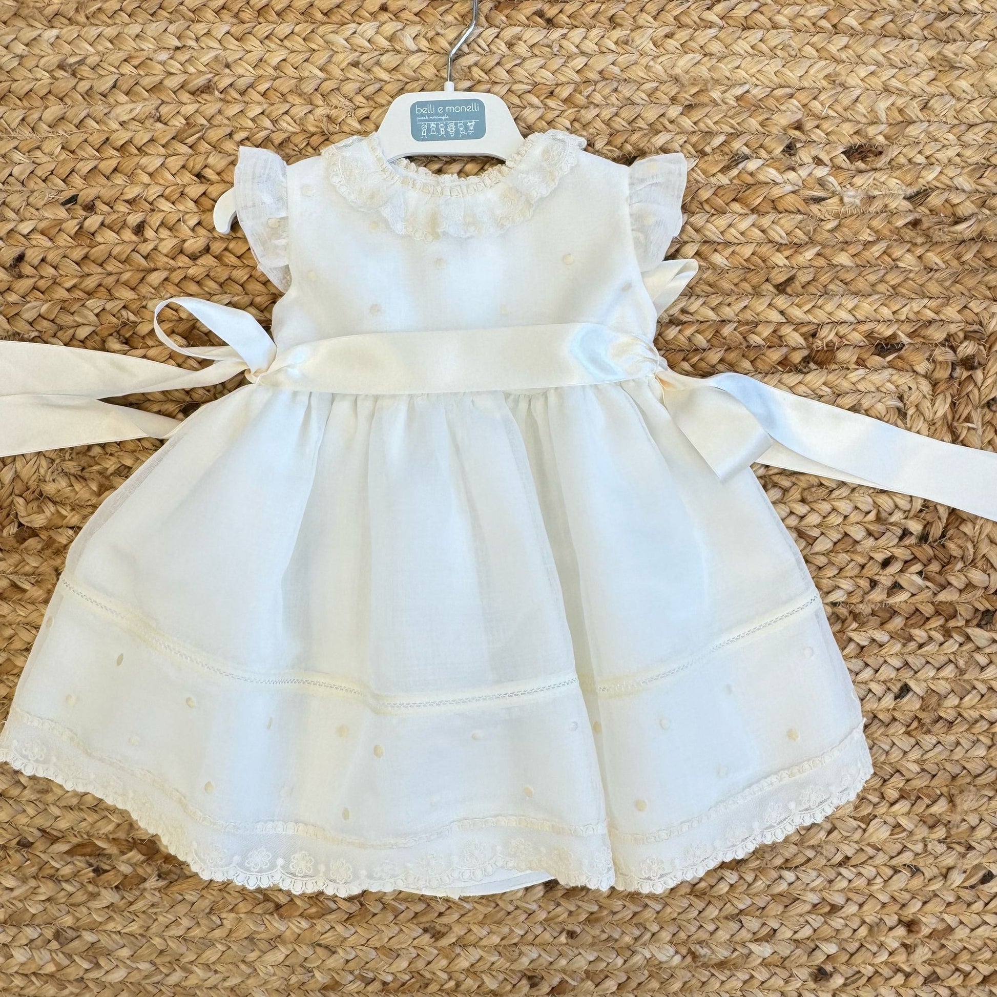 Dettaglio colletto in pizzo floreale su abito battesimo per neonata