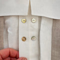 Dettaglio colletto squadrato e doppia fila di bottoncini decorativi sulla camicia bimbo