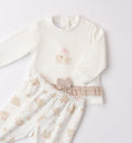Dettaglio del completo neonata con fiocco e volant beige sulla maglia