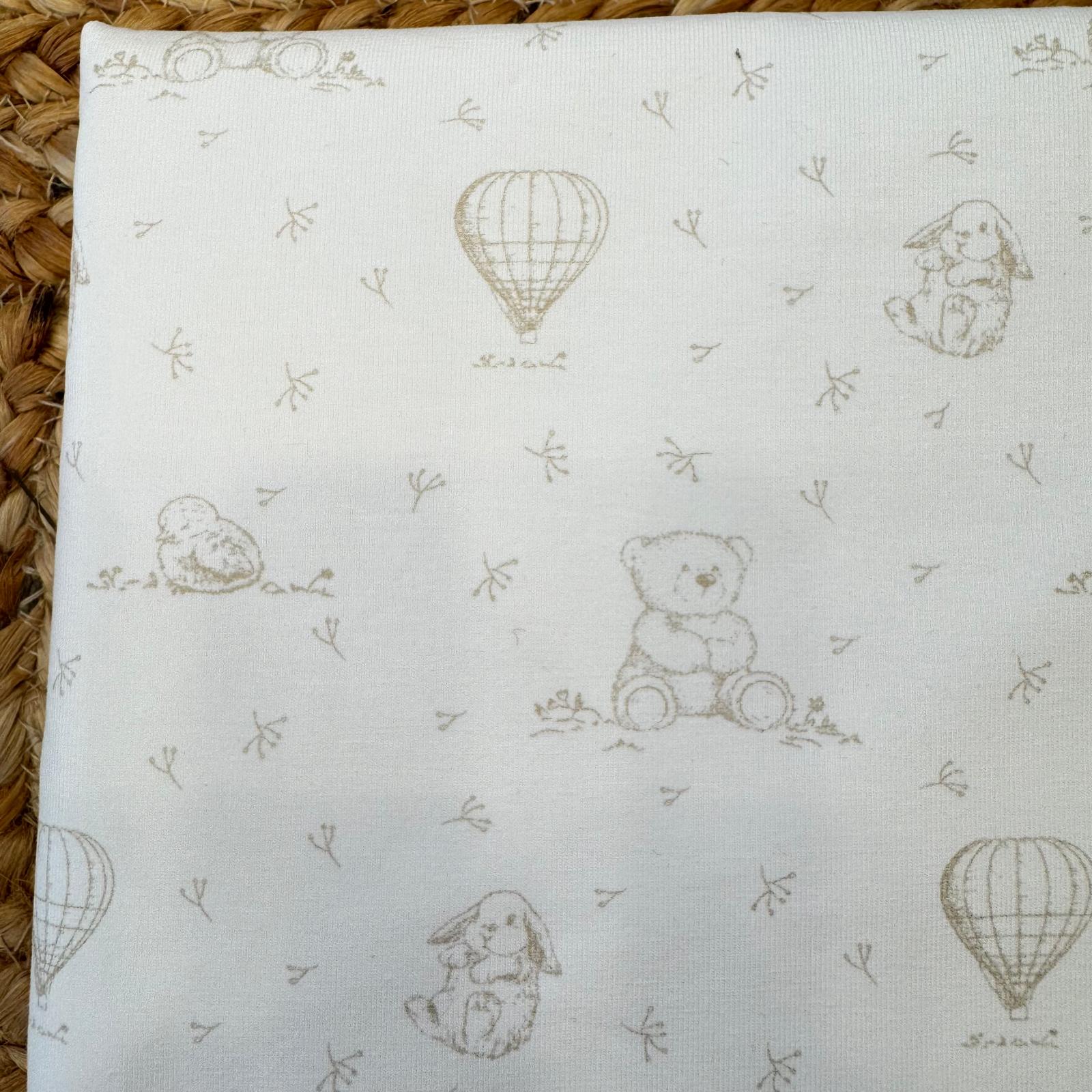 Dettaglio stampa tono su tono con orsetti e mongolfiere su copertina neonato