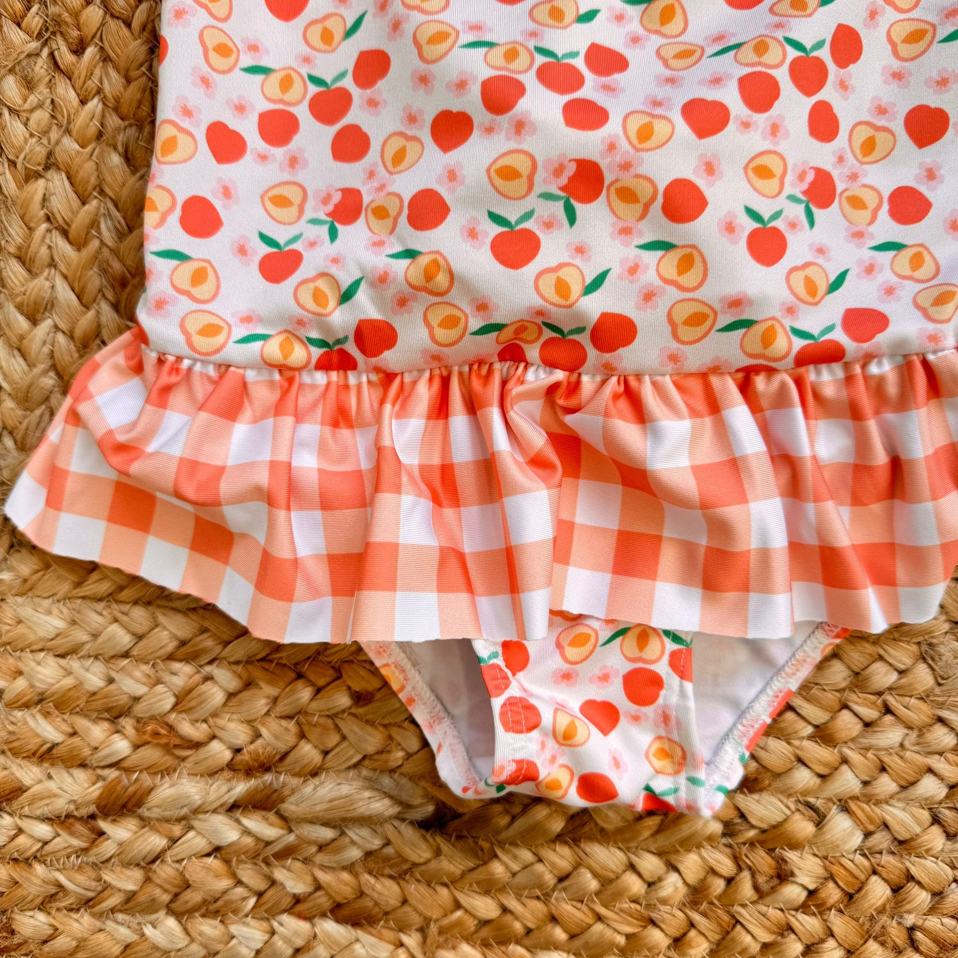 dettaglio costume neonata con balza e stampa fruttata