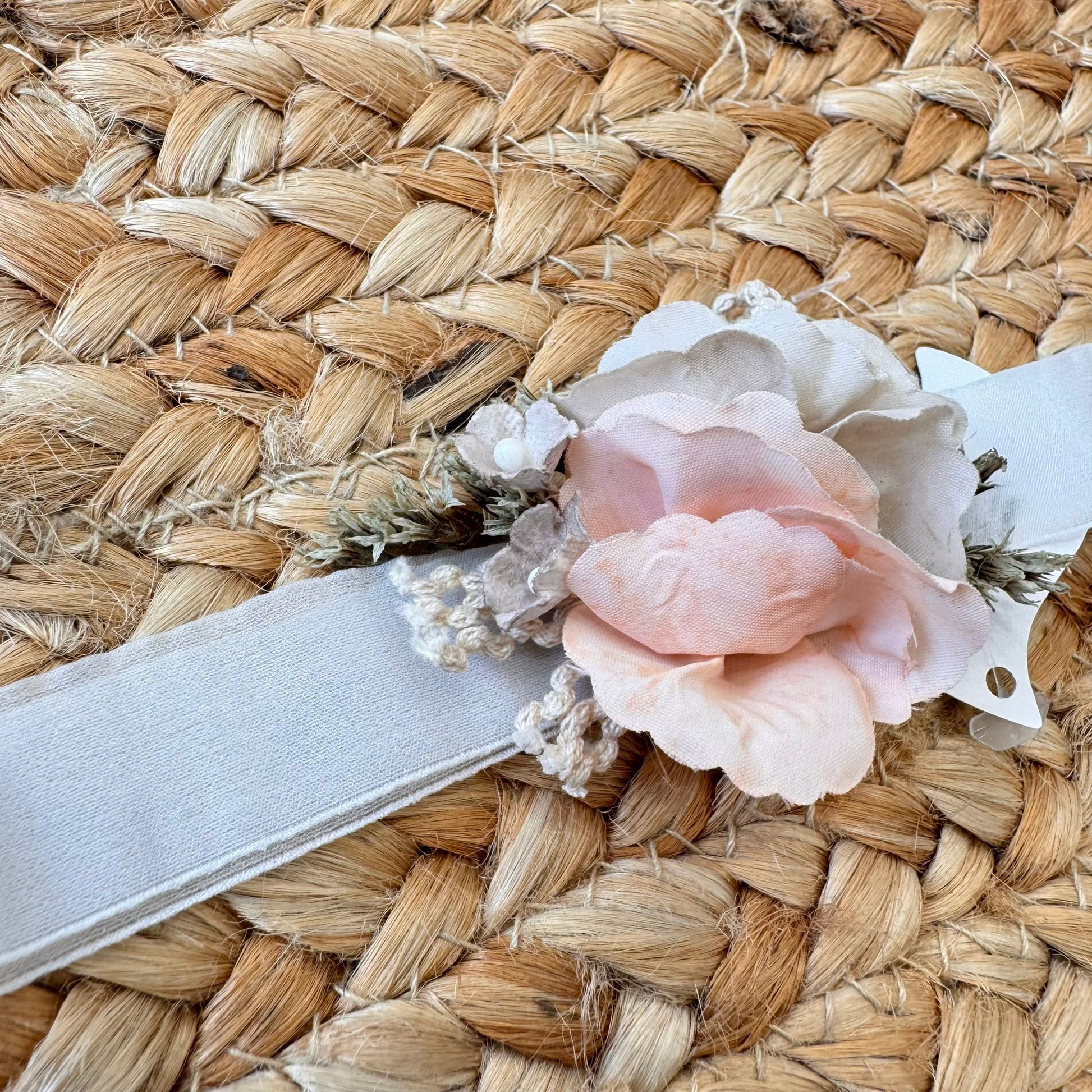 Dettaglio fascia floreale per abito da battesimo bambina