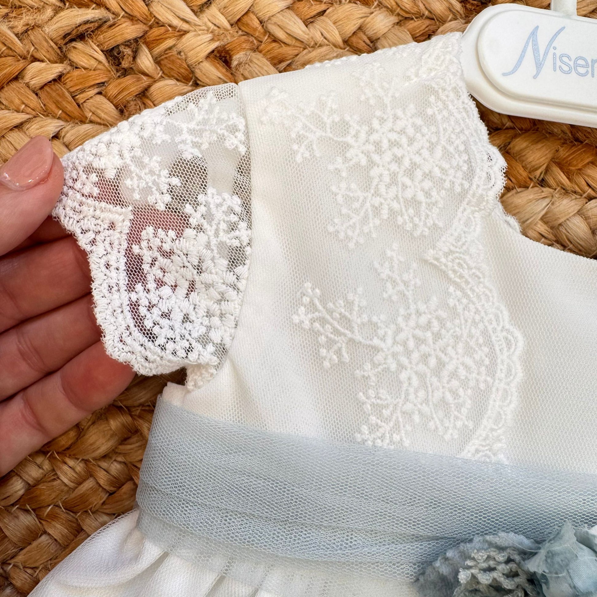 Dettaglio fascia in vita con fiori azzurro polvere su abito bimba