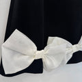 Abito elegante bambina nero con tre maxi fiocchi avorio e maniche a palloncino