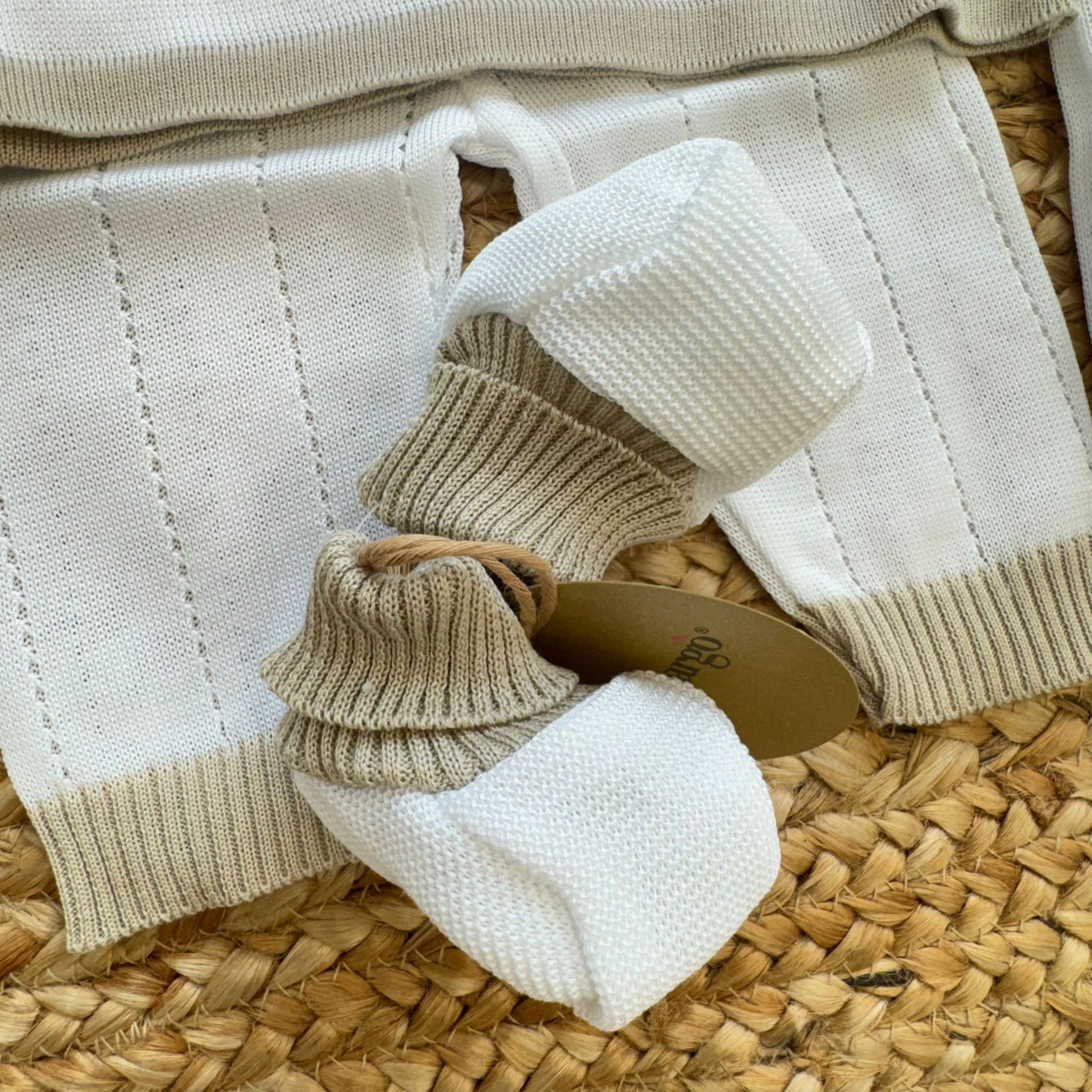 Dettaglio colletto beige e fiocchi ricamati su maglia