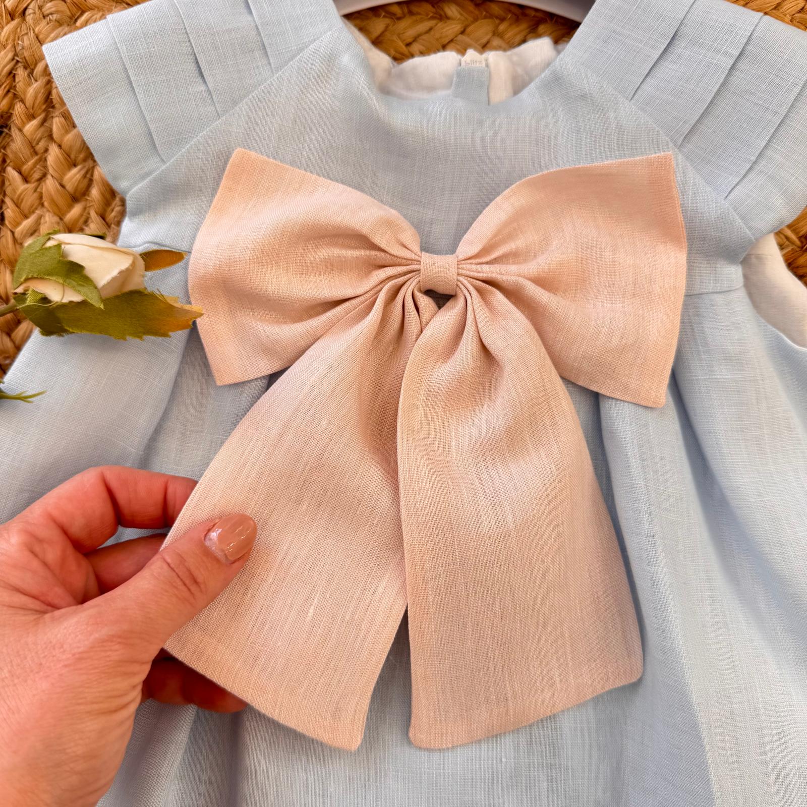 Dettaglio abito bimba elegante in lino con fiocco cipria