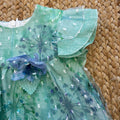 Vestito bambina verde salvia con fiori stampati, volant e fiocco blu

