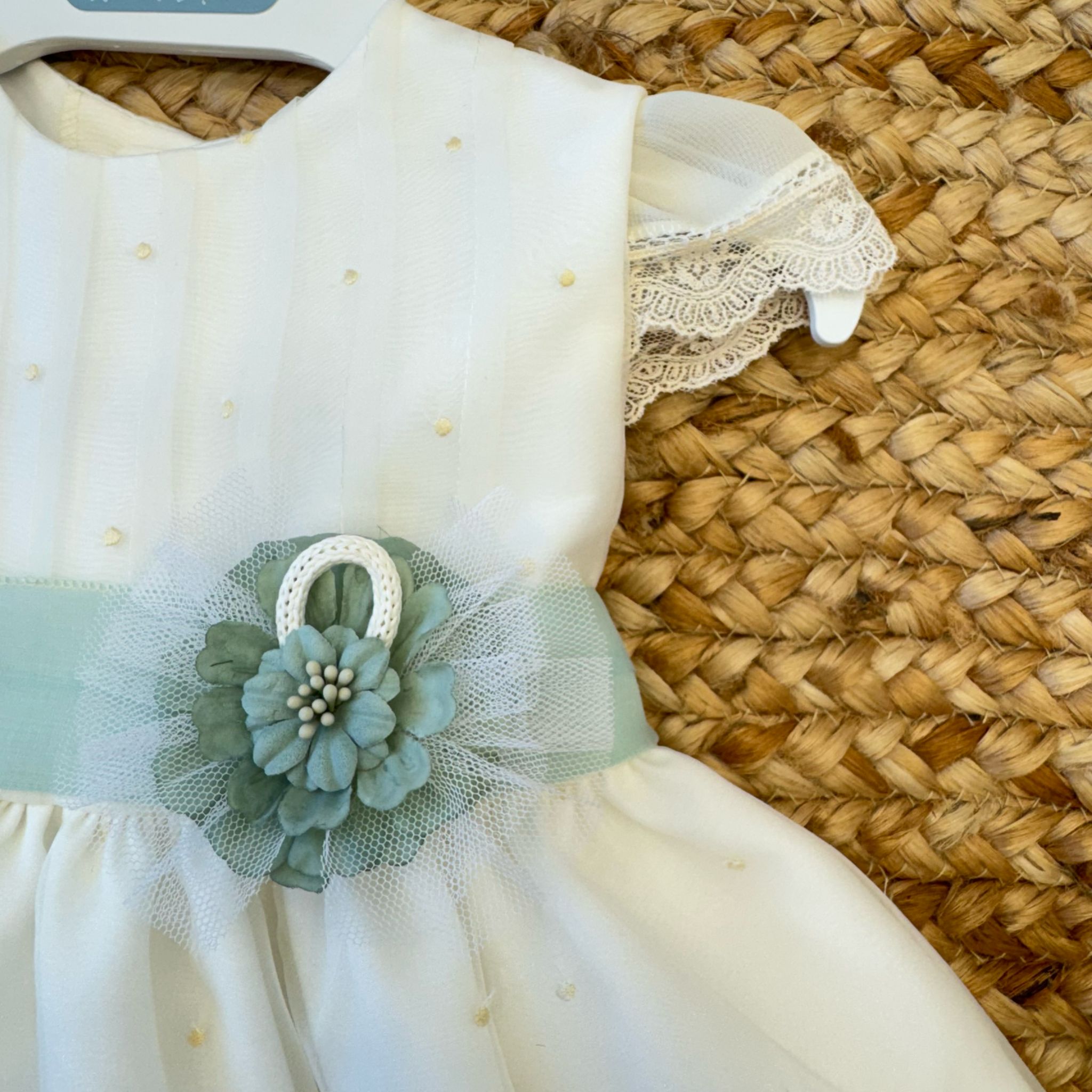 Fiore verde salvia con tulle applicato su fascia in organza dell’abito battesimo neonata