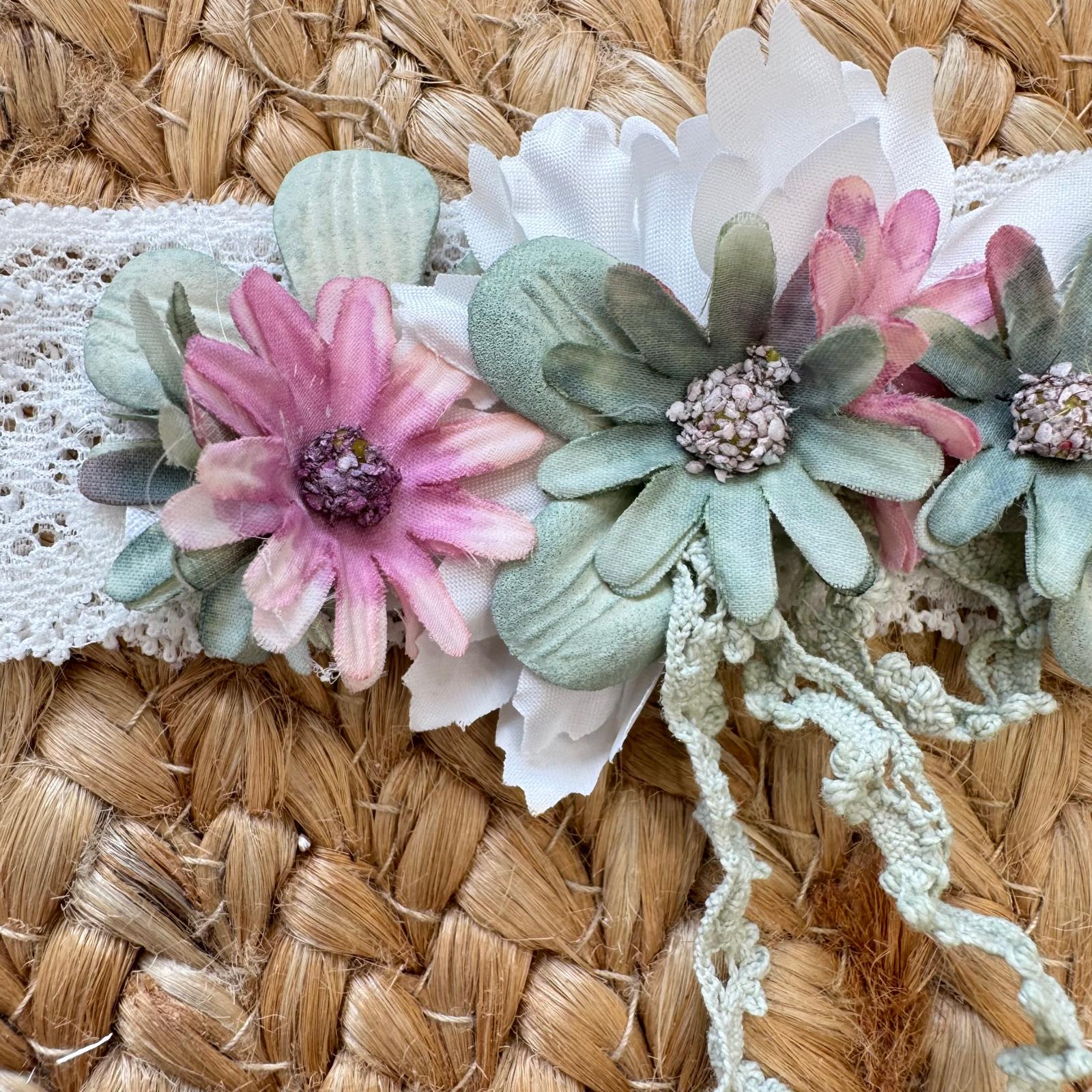 Dettaglio fiori applicati verde salvia e rosa cipria su fascia in pizzo