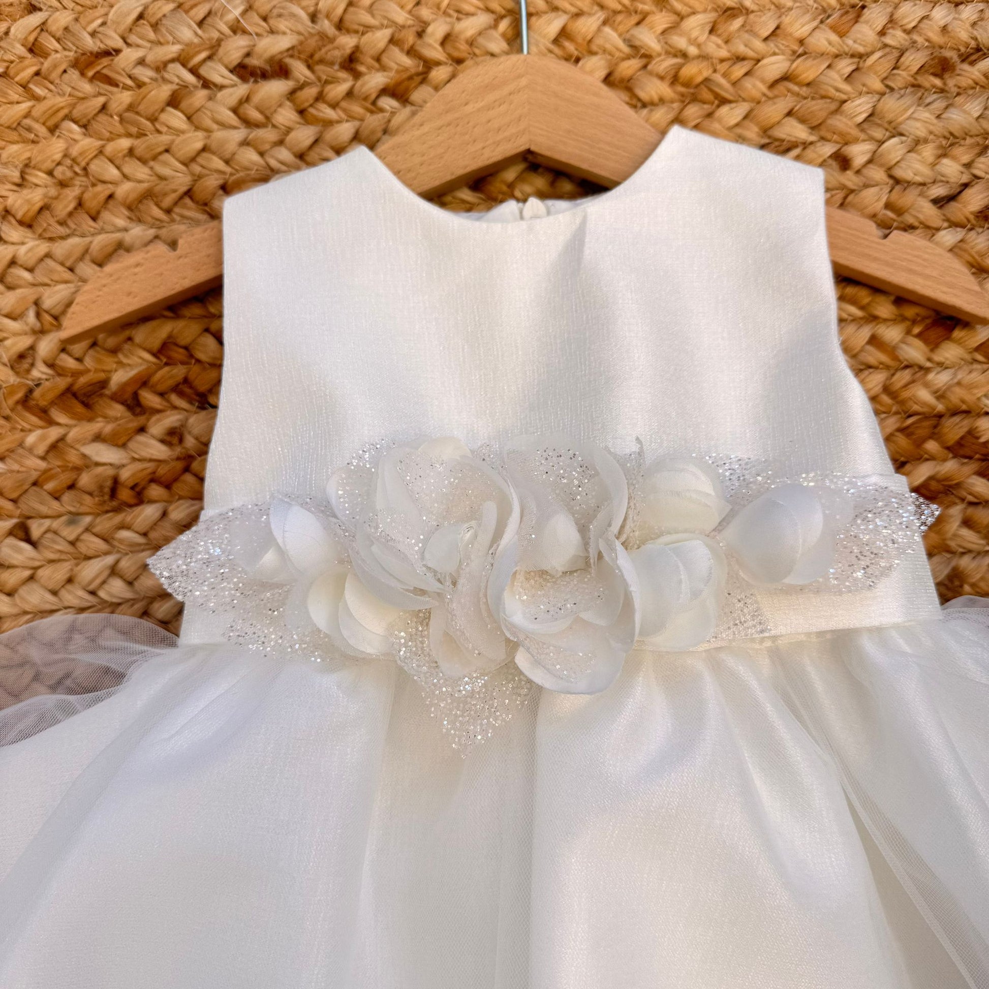Dettaglio frontale abito battesimo bimba bianco con applicazione floreale in vita