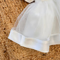 Dettaglio gonna ampia in tulle con fondo rifinito abito elegante bimba bianco