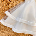 Dettaglio gonna ampia con tulle e bordo rifinito abito elegante bimba bianco