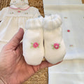 dettaglio maglia neonata con colletto rosa e ricami