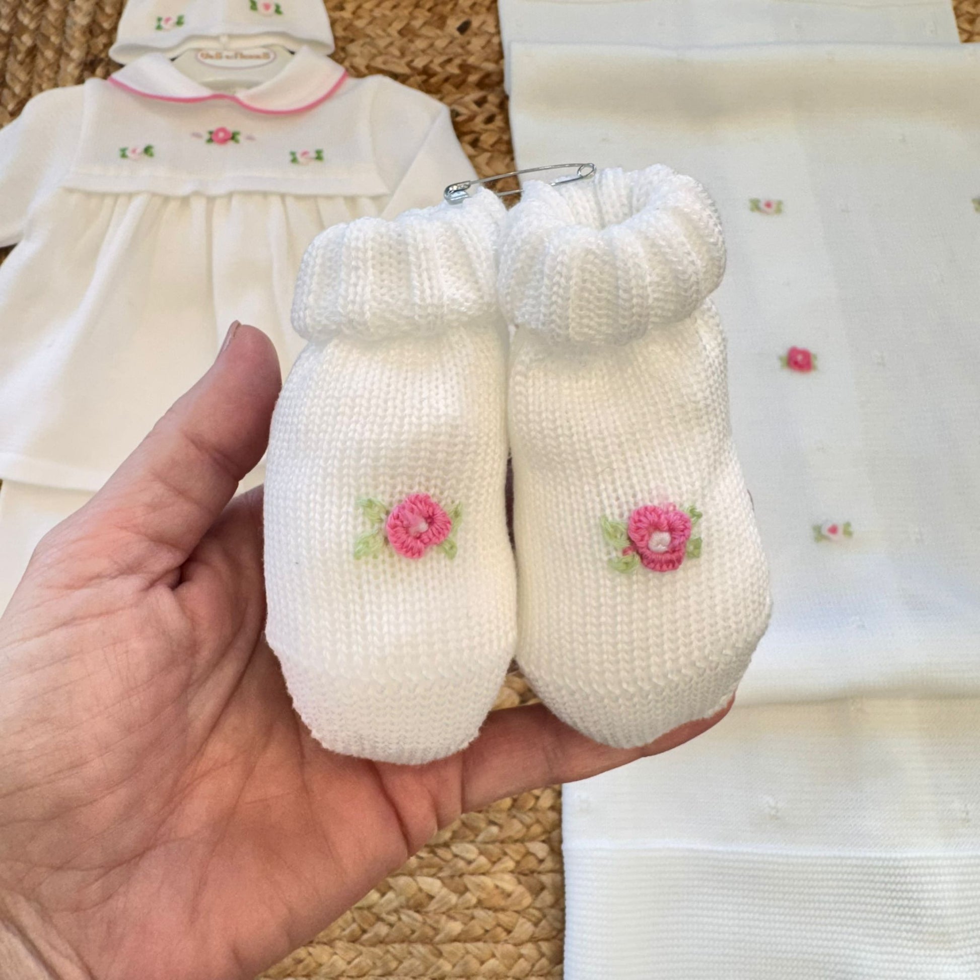 dettaglio maglia neonata con colletto rosa e ricami