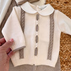 Zoom sul maglioncino panna con lavorazione trecce beige del completino caldo per neonato inverno