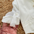 dettaglio manica camicia con linguetta e bottone