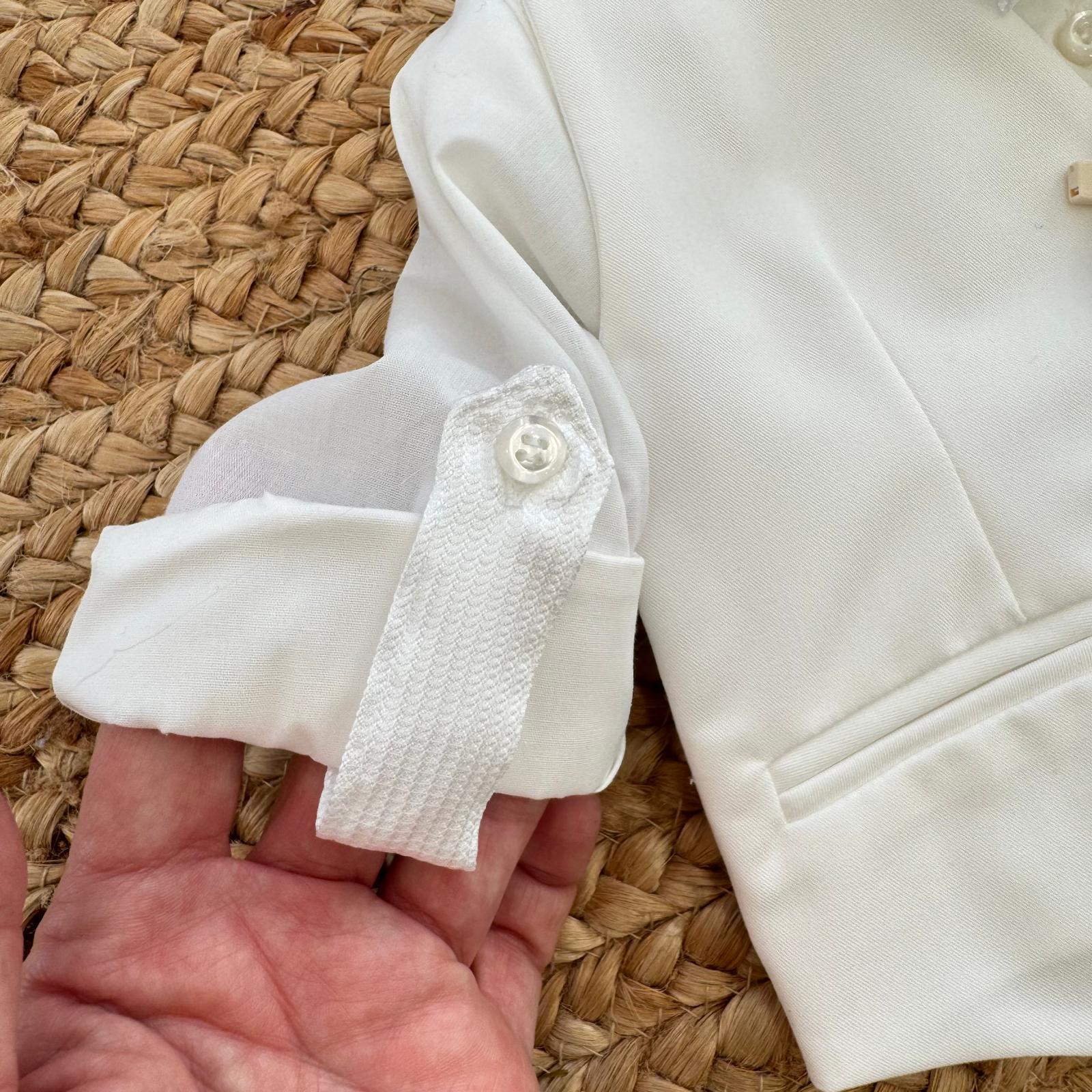 dettaglio manica camicia con linguetta e bottone