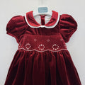 Abito bimba in velluto bordeaux con punto smock, colletto bianco a contrasto e maniche a palloncino.