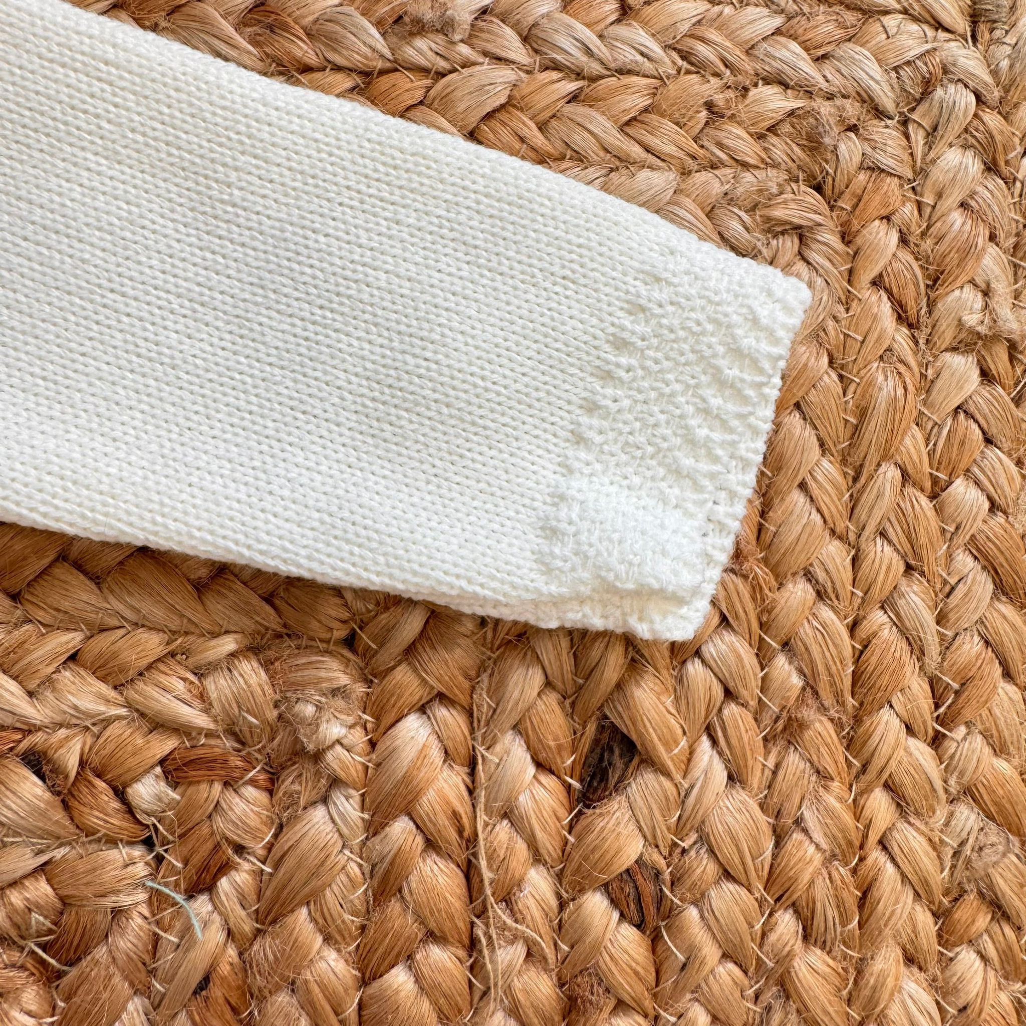 Dettaglio manica lunga maglia panna in tricot con bordo lavorato per neonata