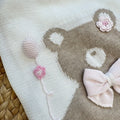dettaglio orsetto con fiocco rosa e fiori ricamati