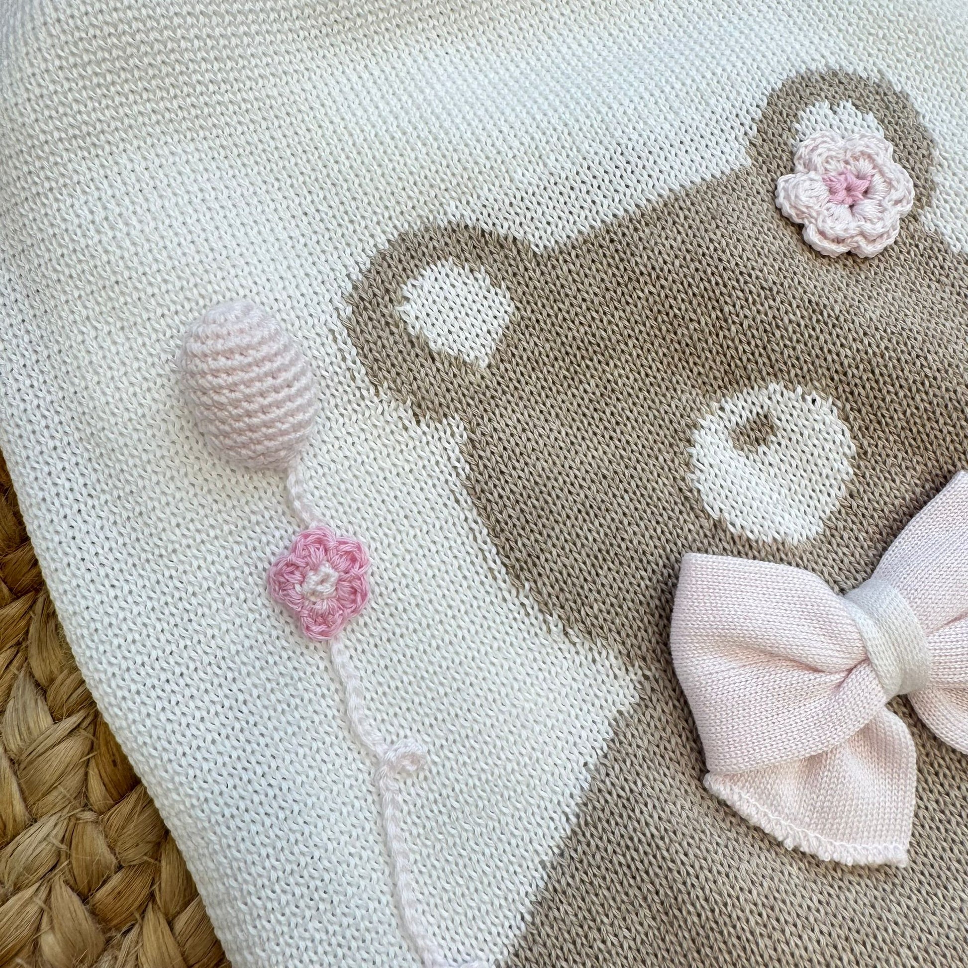 dettaglio orsetto con fiocco rosa e fiori ricamati