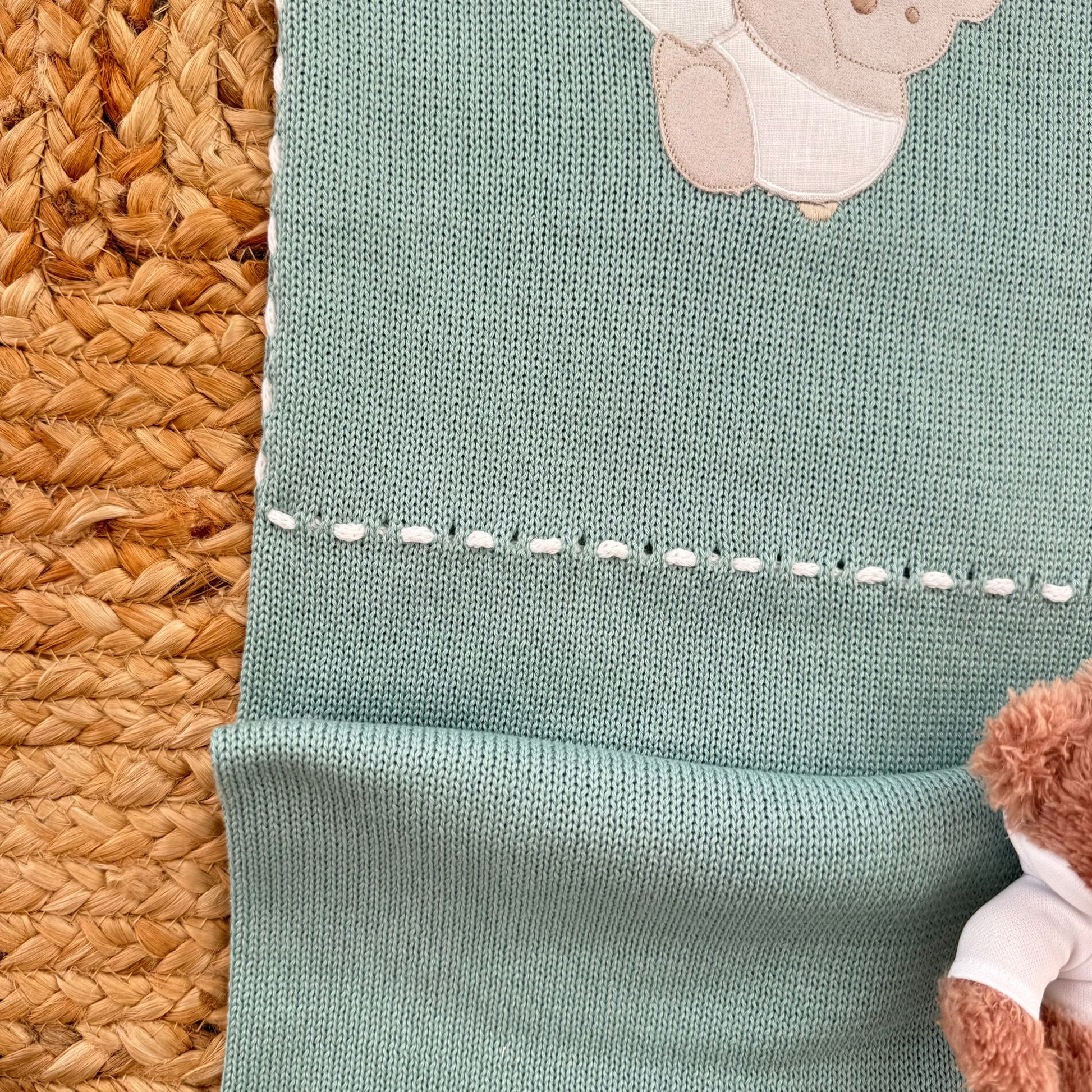 dettaglio ricamo orsetto su maglia neonato in cotone