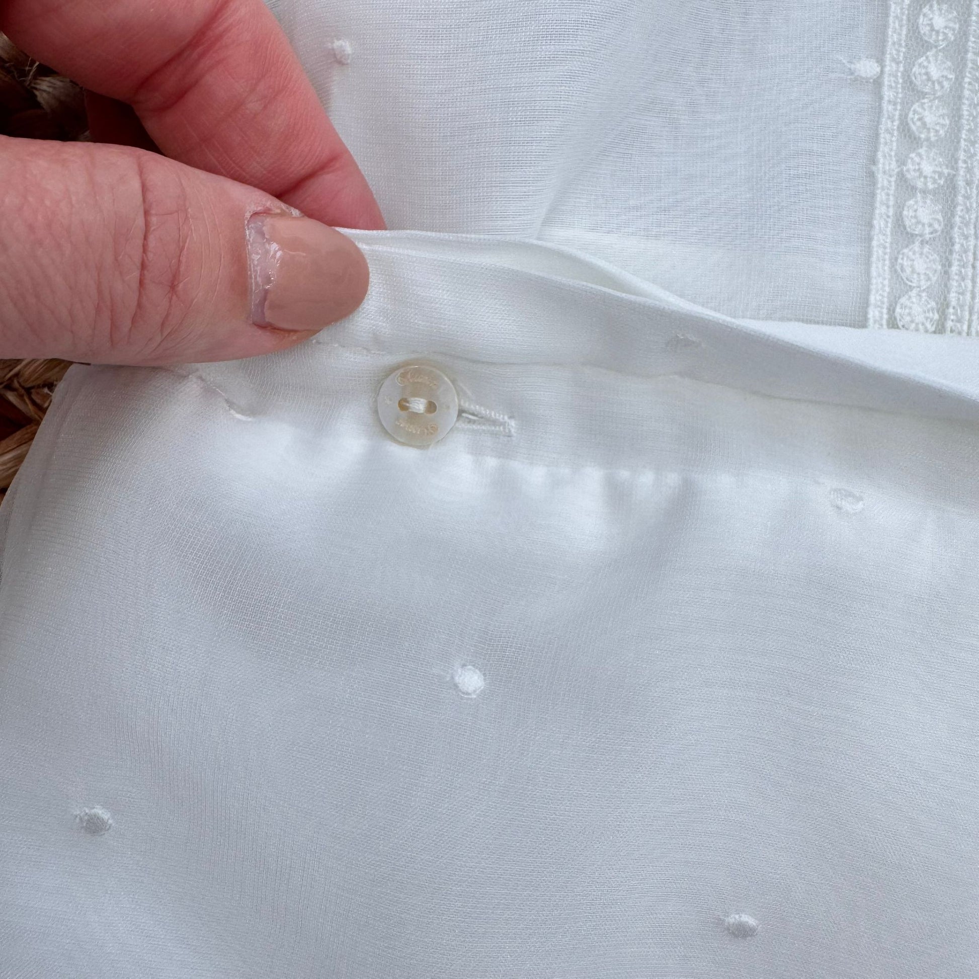 Dettaglio pantaloncino bianco con piccoli pois in rilievo completo battesimo bimbo