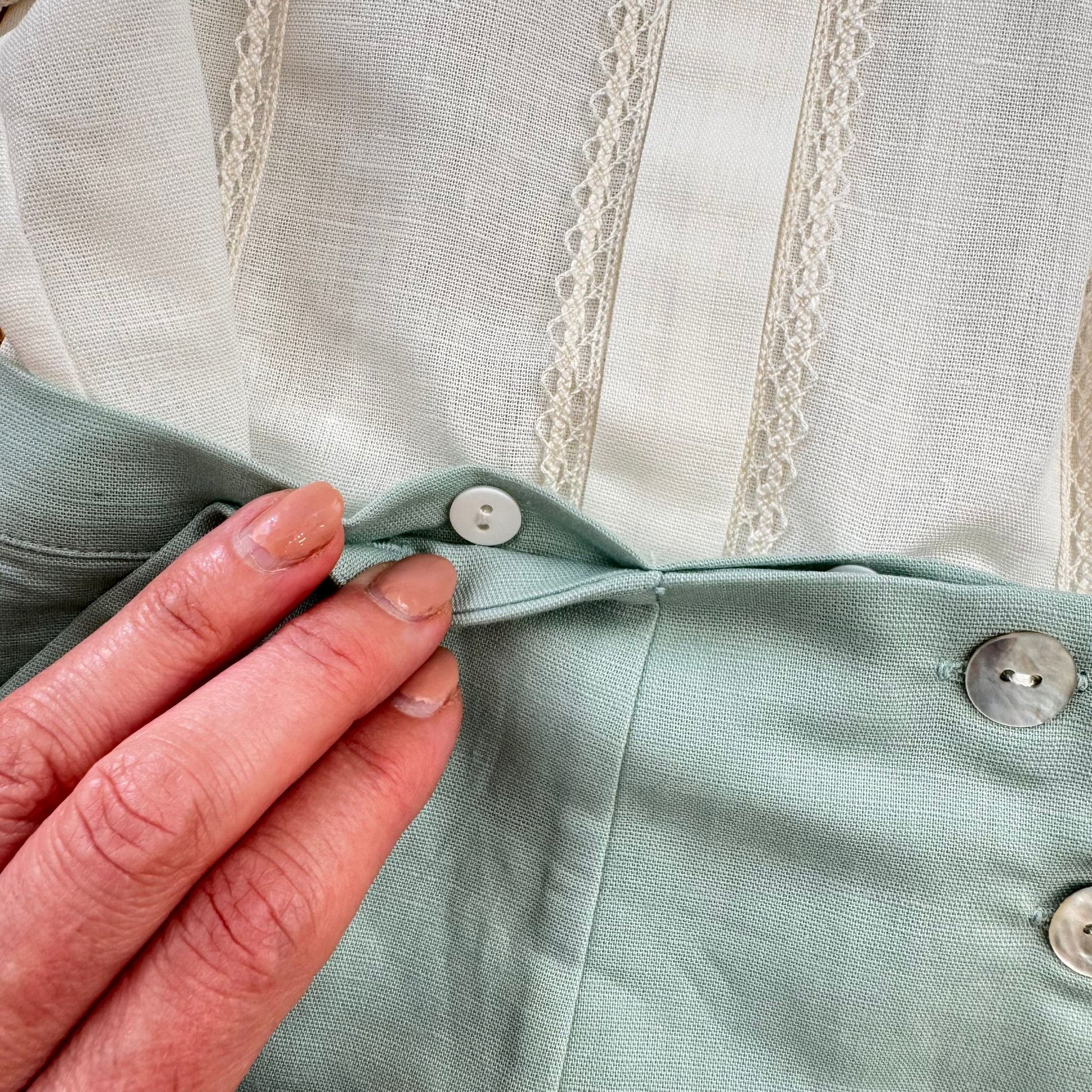 Dettaglio pantaloncino verde salvia con bottoncini decorativi frontali