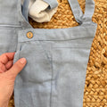 dettaglio pantalone con bretelle e bottoni effetto legno completo cerimonia neonato