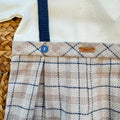 Tutina neonato in caldo cotone panna con salopette beige a quadri e bretelle blu Made in Italy.