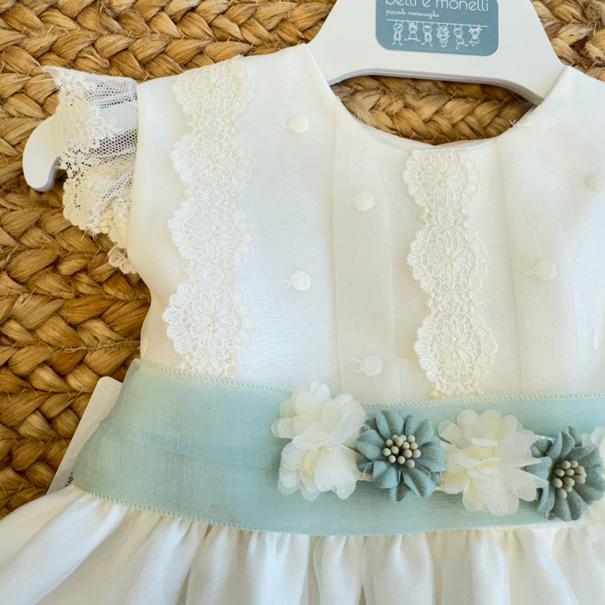 Dettaglio corpetto con pizzo floreale e pois su abito battesimo neonata