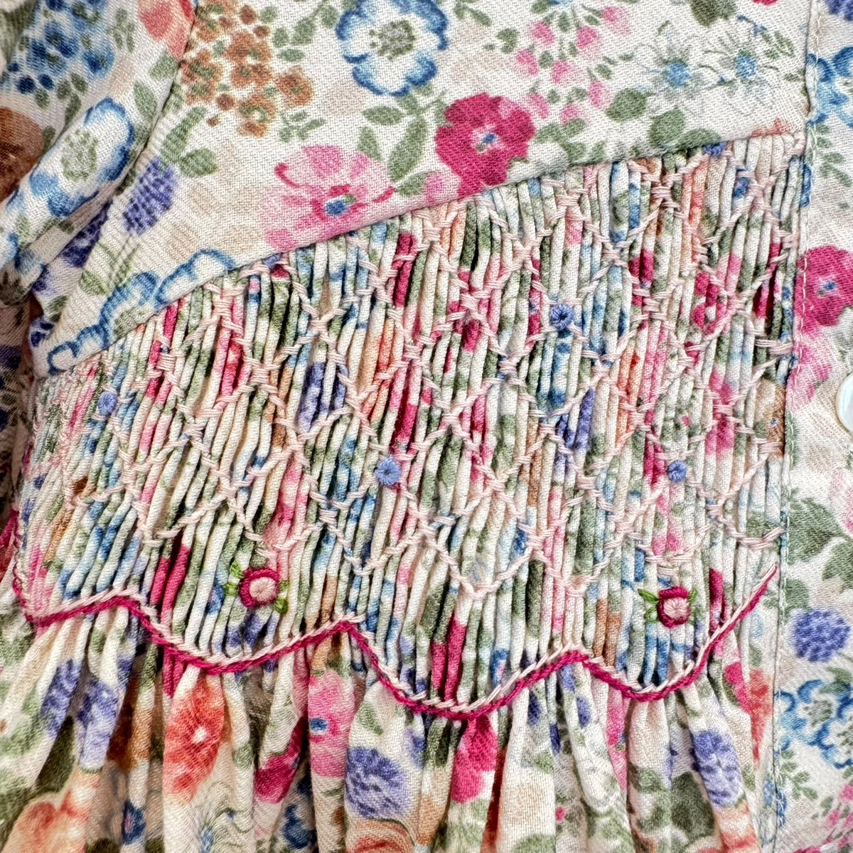 Abito bambina floreale in cotone con punto smock, colletto arricciato e dettagli bordeaux Kidivi.