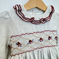 Abito bimba grigio chiaro in cotone con punto smock, ricami floreali e colletto a volant bordeaux.