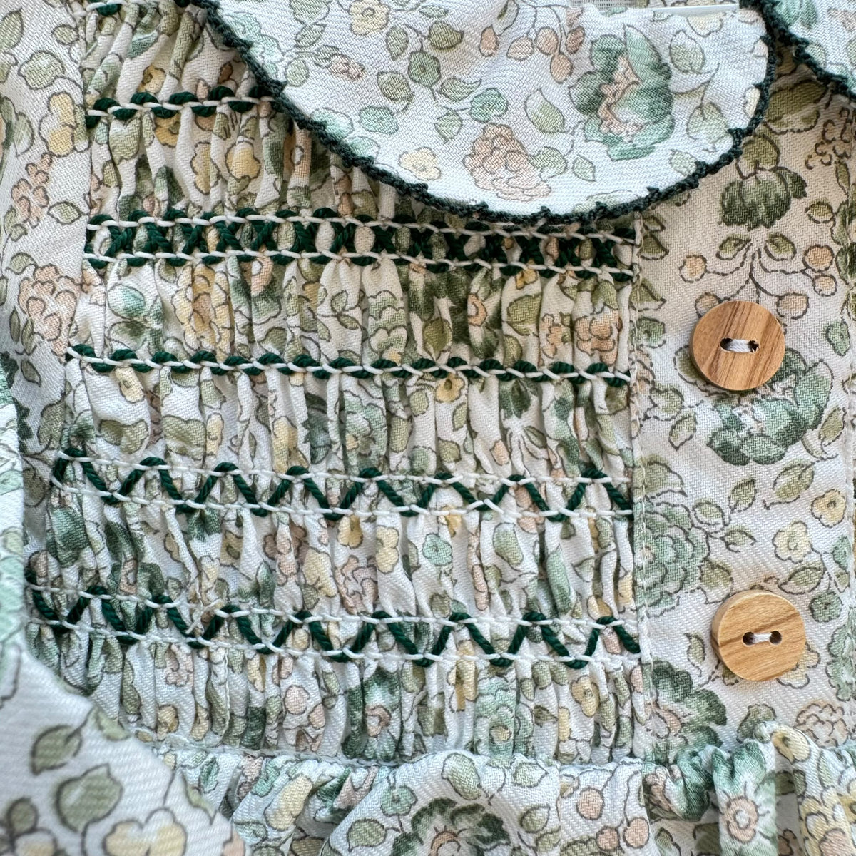Pagliaccetto bimba floreale verde Sardon in 100% cotone con punto smock