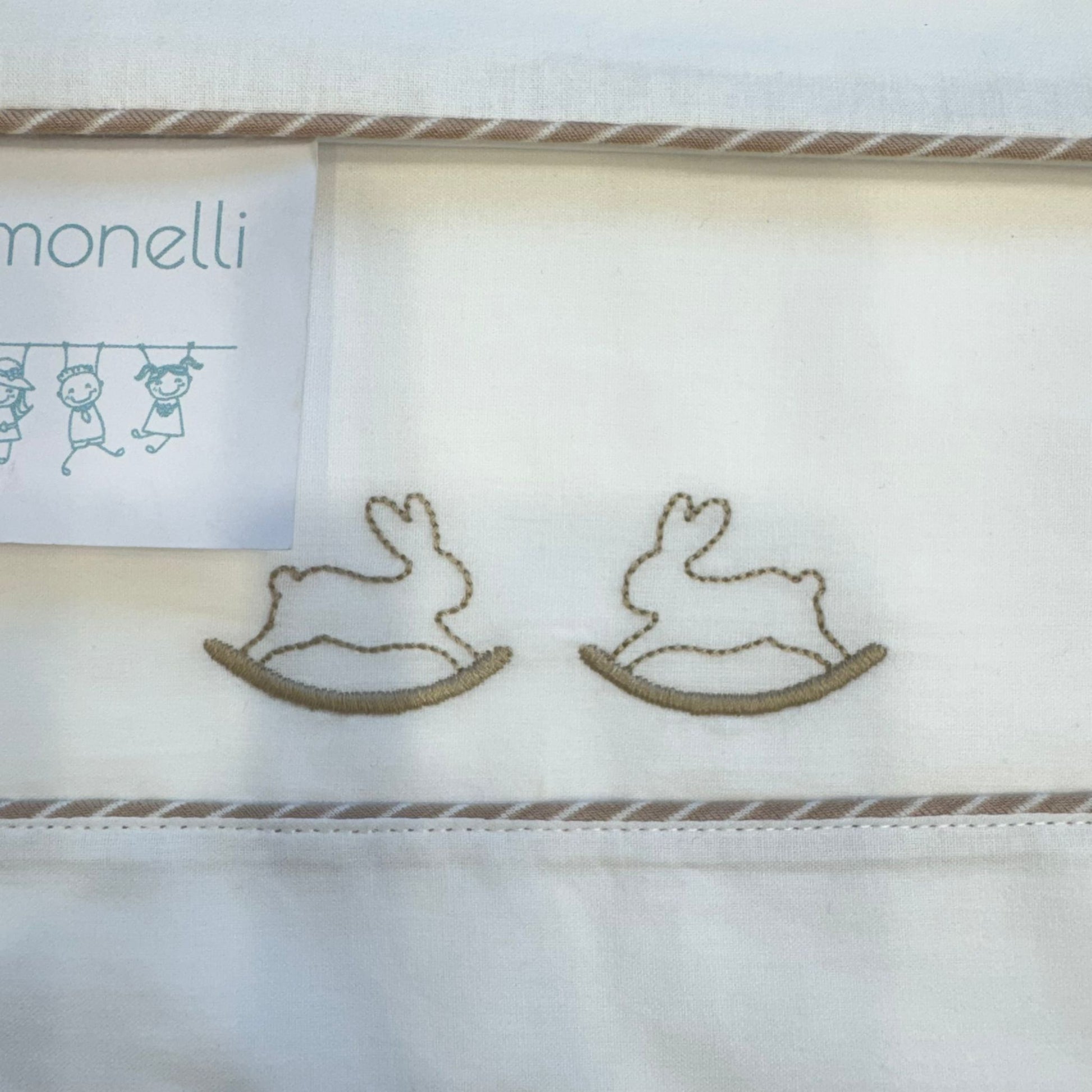 dettaglio ricamo coniglietti su lenzuolo sopra neonato