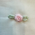 Set lenzuola culla e carrozzina in cotone colore latte con federa ricamata a fiori rosa per neonata.