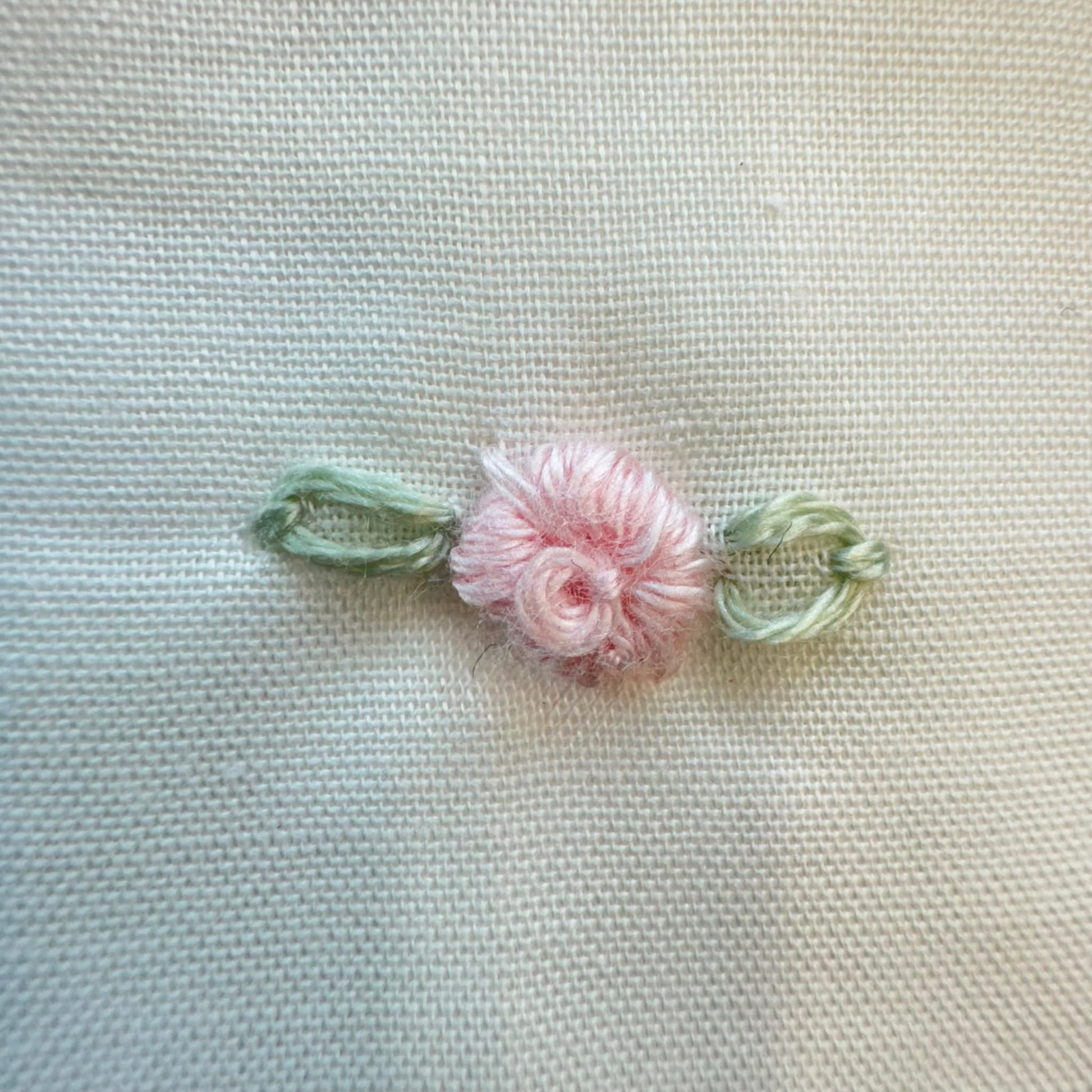 Set lenzuola culla e carrozzina in cotone colore latte con federa ricamata a fiori rosa per neonata.