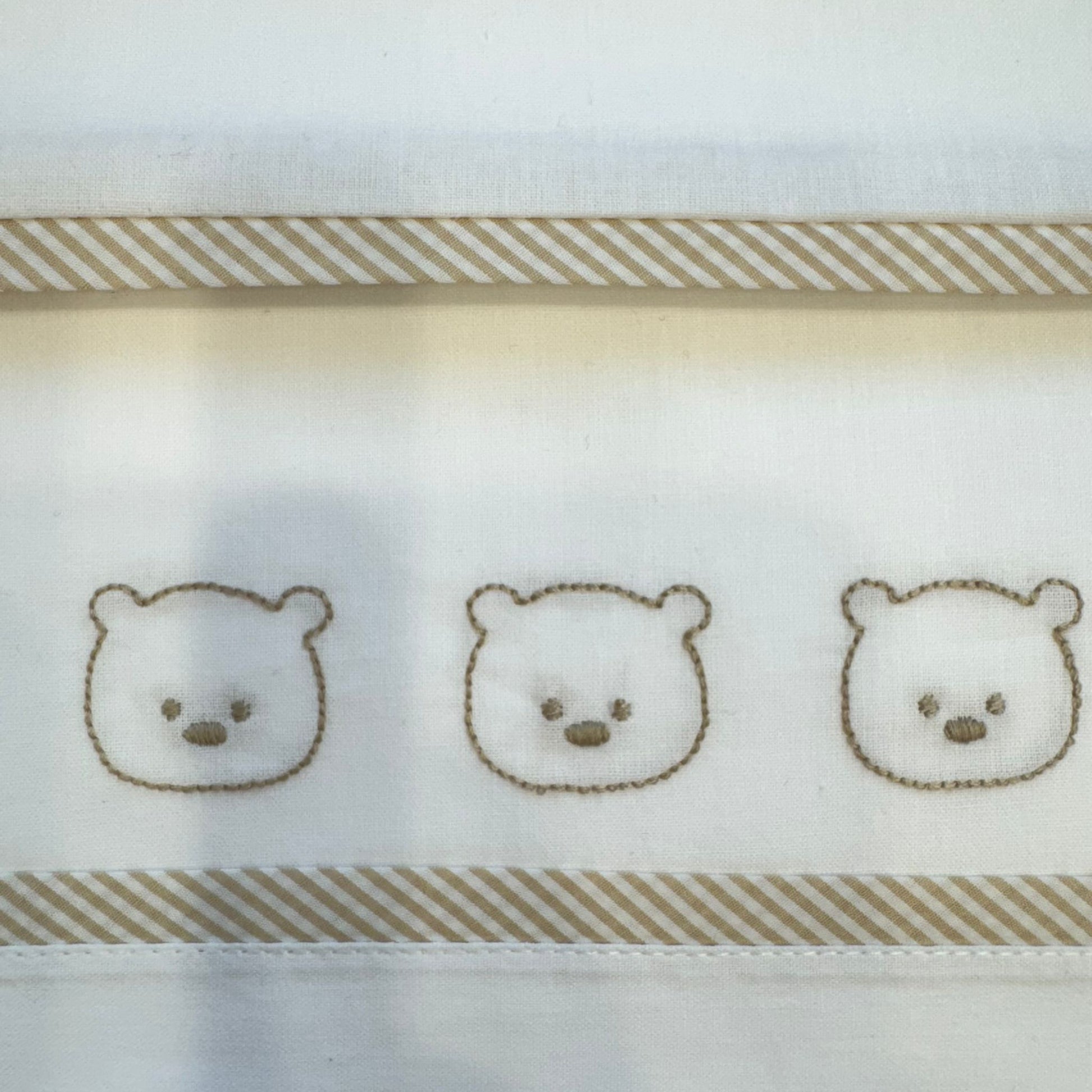 dettaglio ricamo tre orsetti su lenzuolo sopra neonato