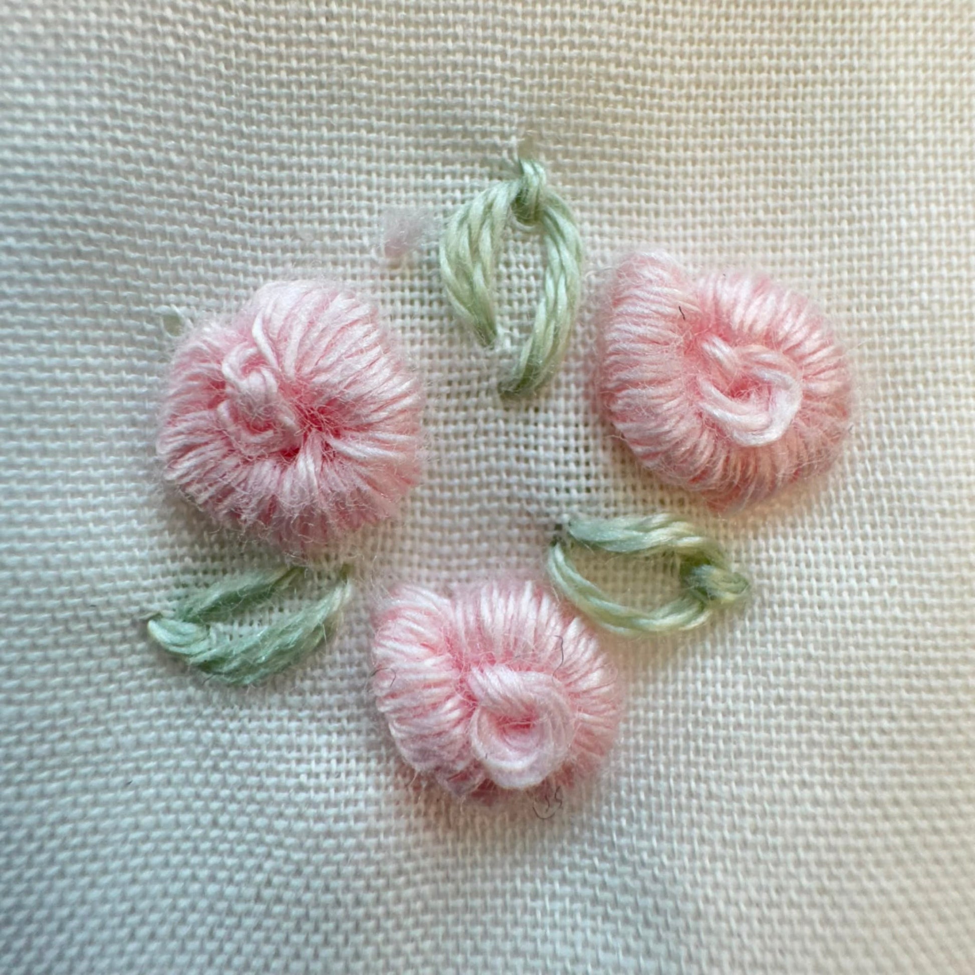 Set lenzuola culla e carrozzina in cotone colore latte con federa ricamata a fiori rosa per neonata.