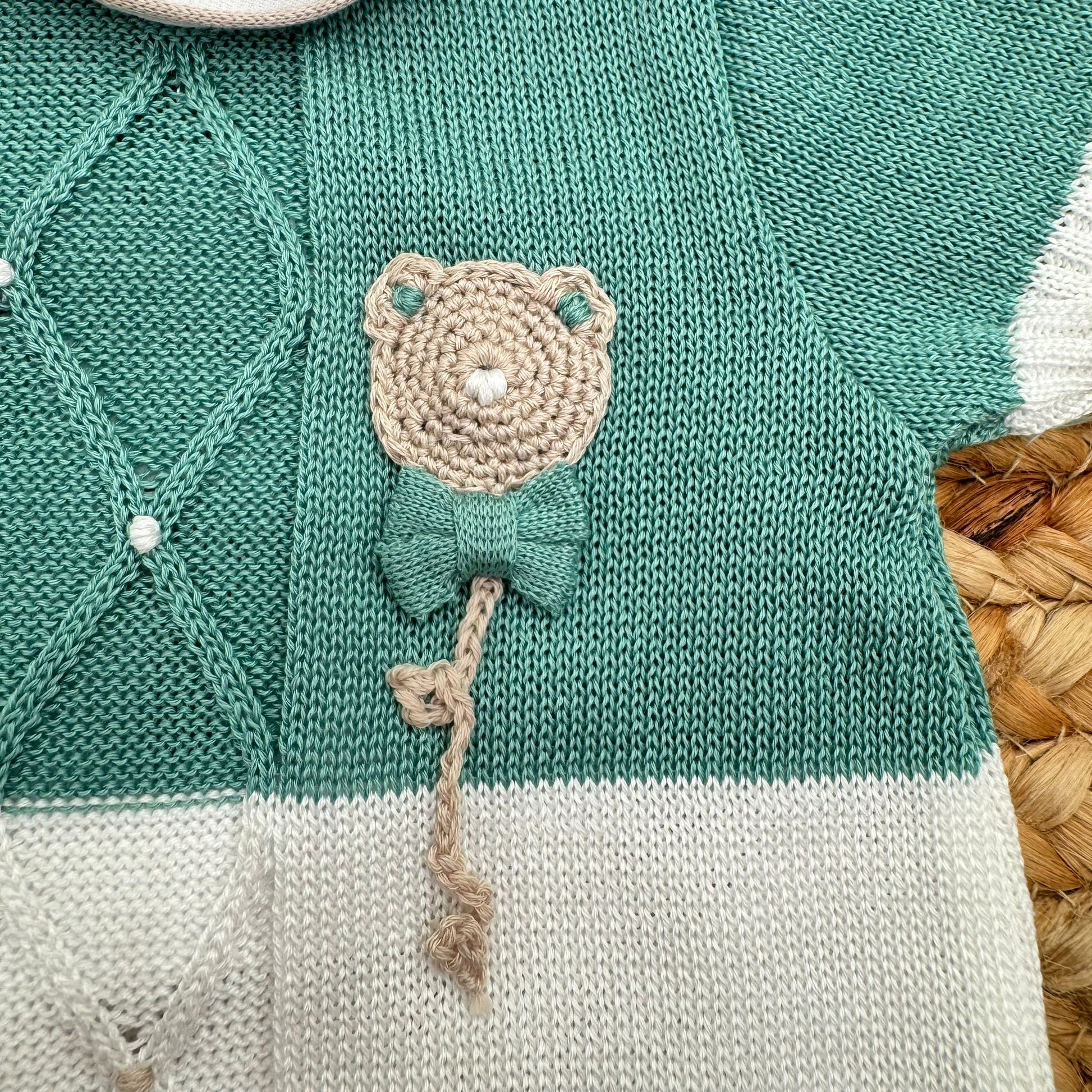 Dettaglio lavorazione rombi pagliaccetto neonato in cotone con applicazione orsetto