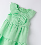 Dettaglio rouches su vestito verde bambina