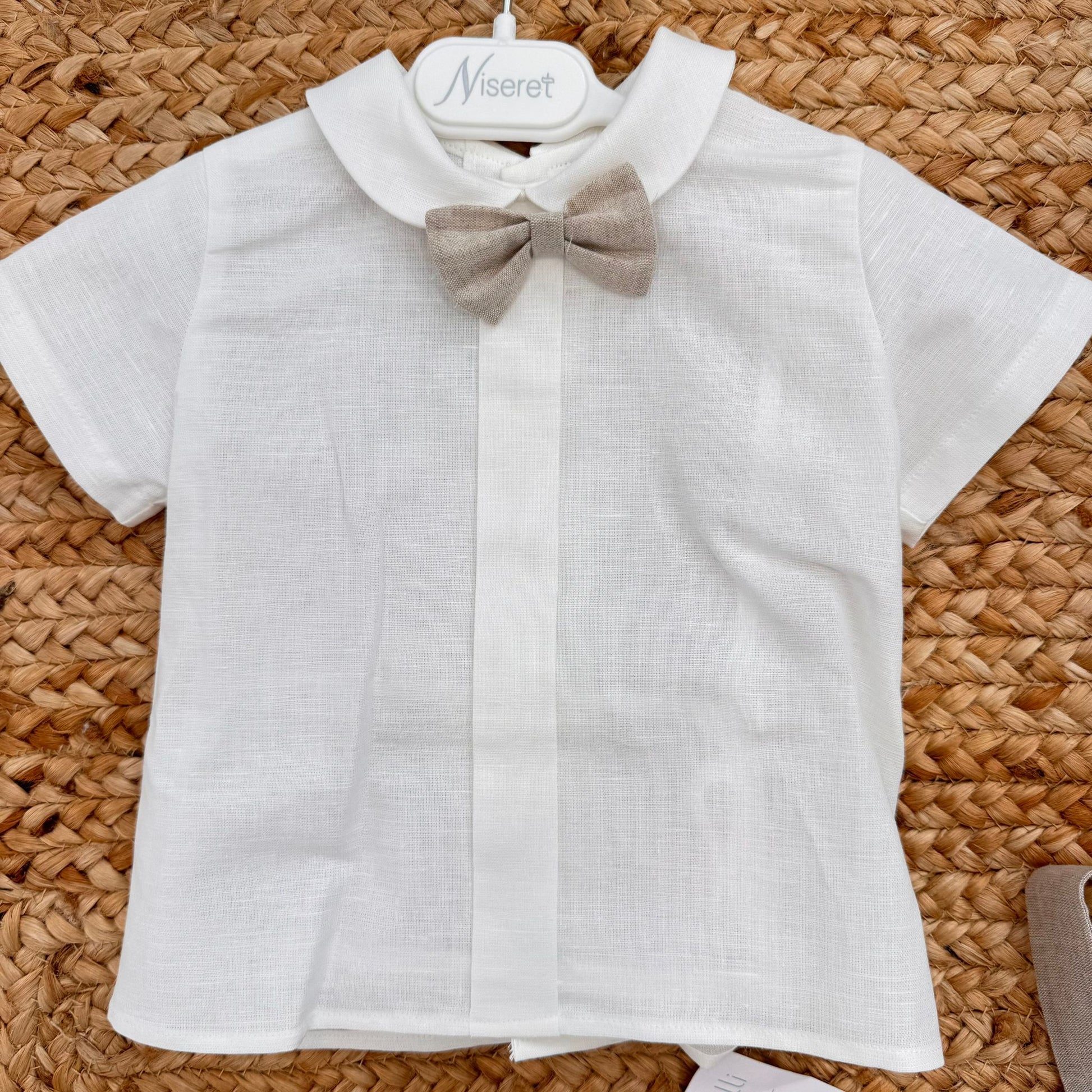 Dettaglio salopette battesimo bimbo beige con bottone effetto legno