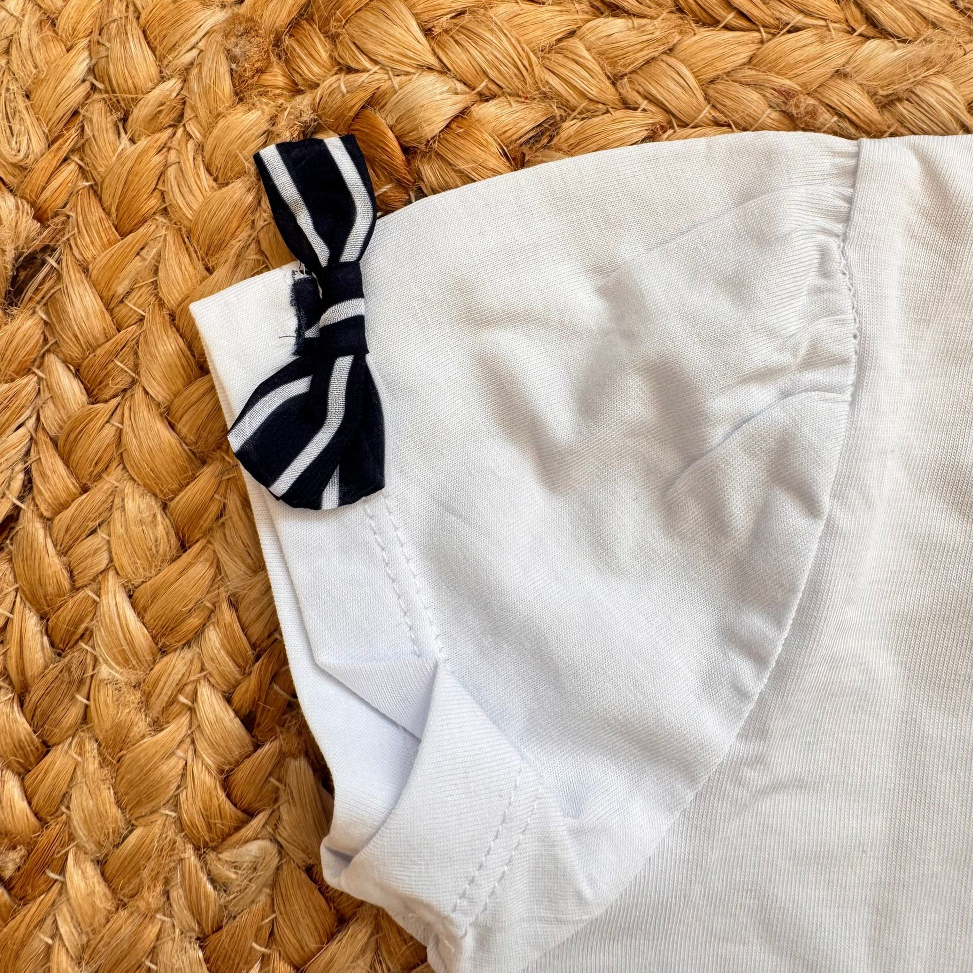 dettaglio t-shirt bimba con stampa floreale e fiocchi maniche