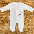 Tutina neonata in ciniglia panna con ricami floreali e fiocco rosa Made in Italy.