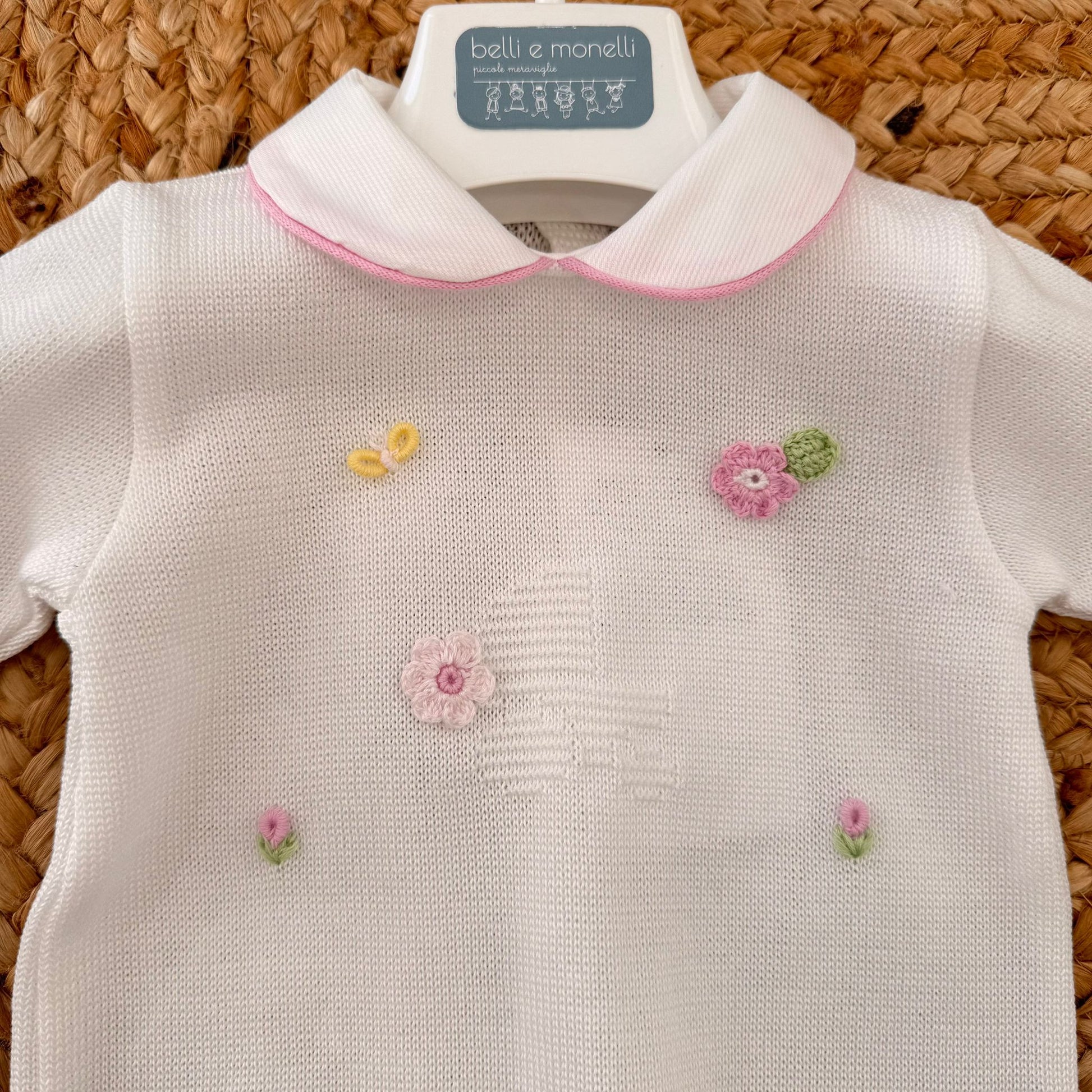 dettaglio tutina neonata con colletto rosa e ricamo fiori