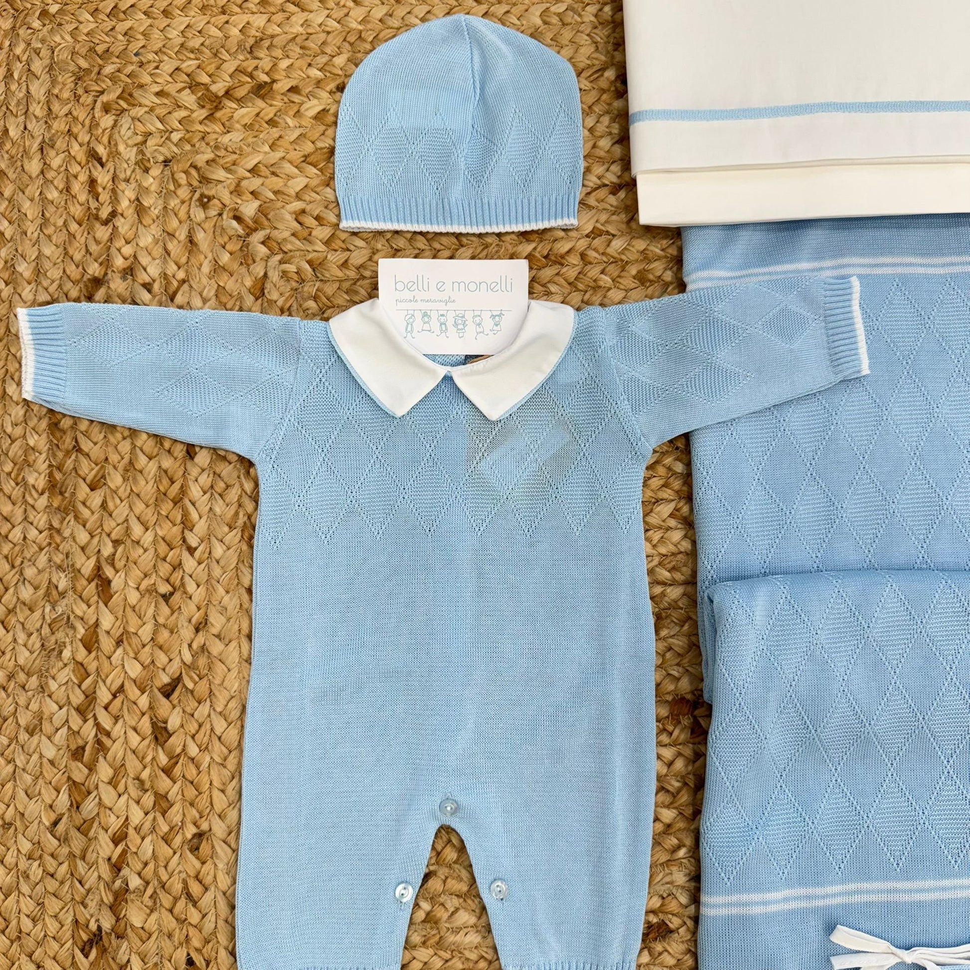 Dettaglio tutina neonato azzurra in 100% cotone con colletto bianco e lavorazione a rombi